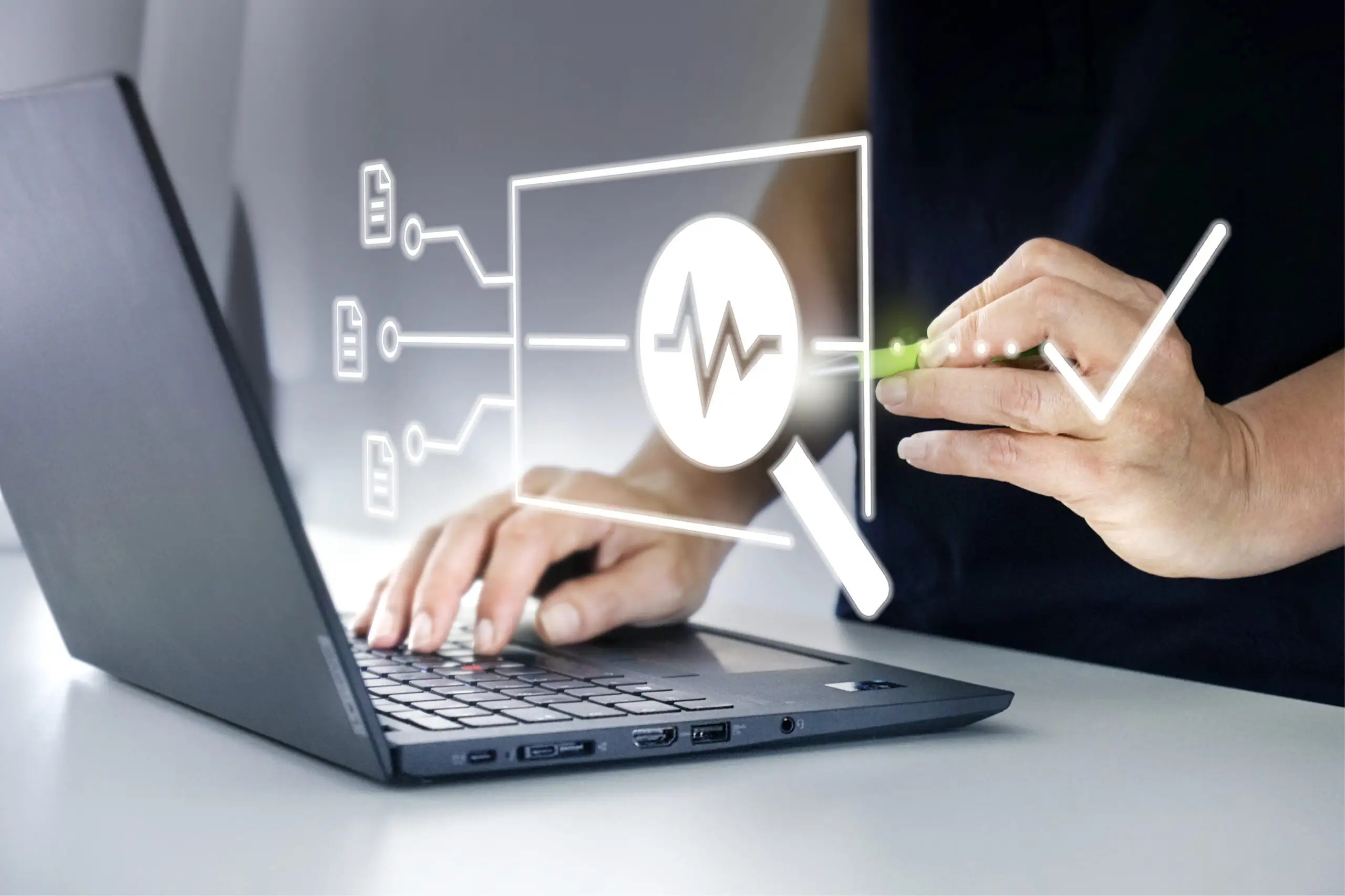 Person arbeitet am Laptop und interagiert mit holografischer Oberfläche mit Gesundheits-Icons und Herzfrequenzsymbol.
