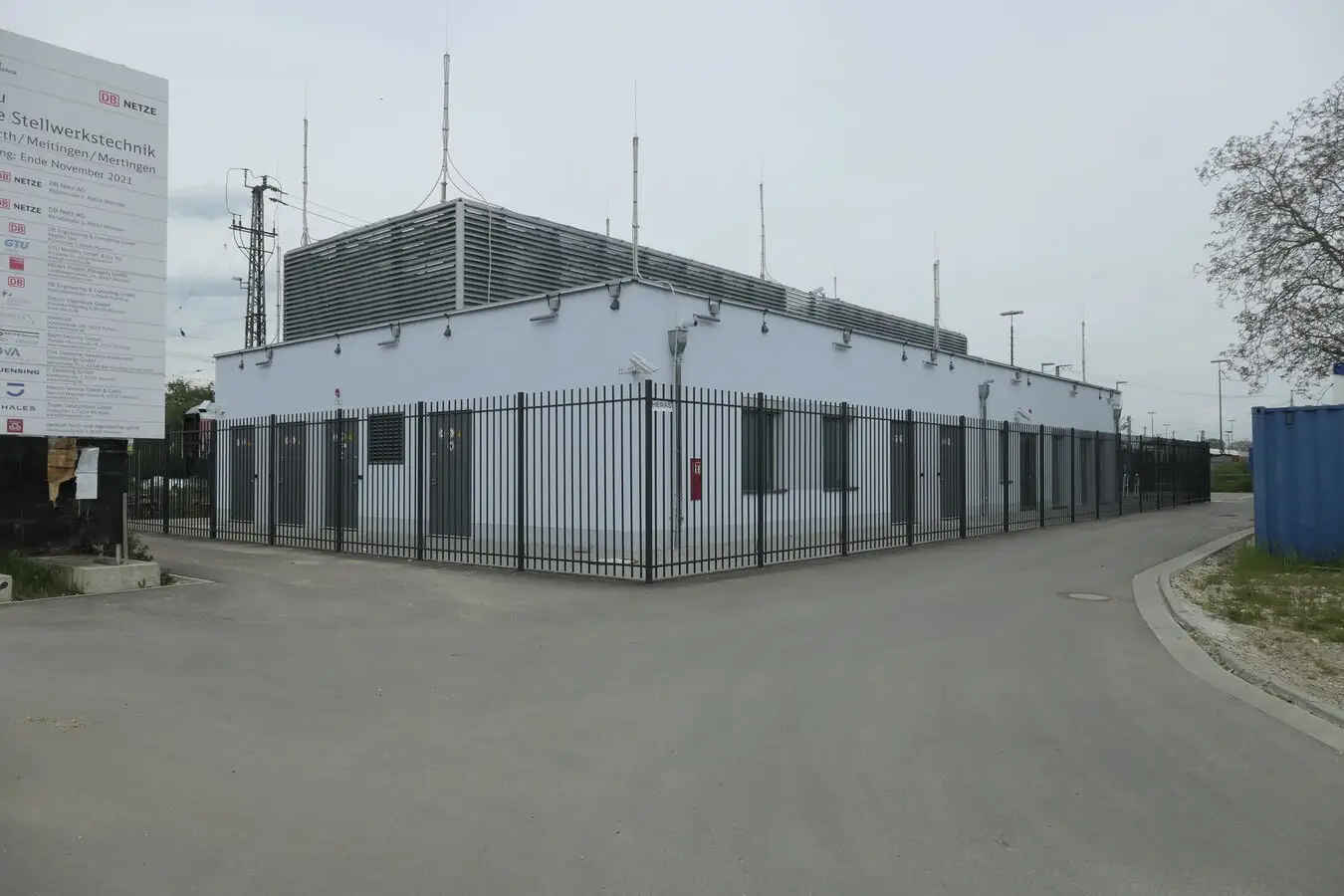 Modernes Technikgebäude mit Antennen und Zaun, Schild mit Hinweis auf Stellwerkstechnik.